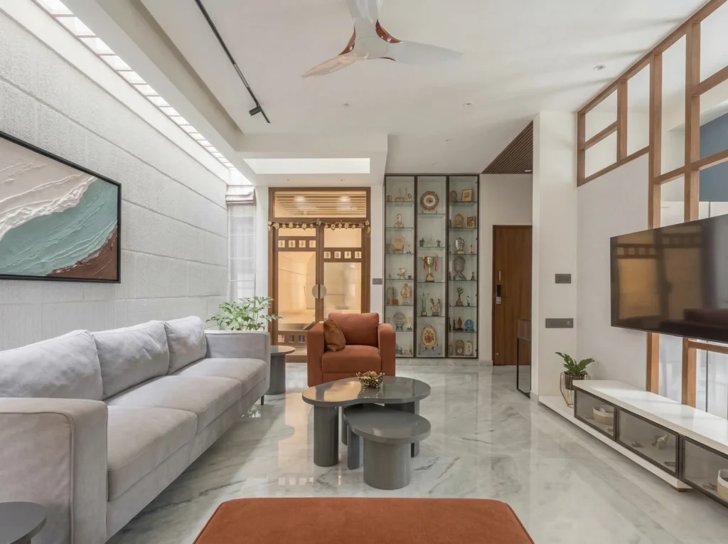 Spacious modern living hall with an integrated ceiling skylight, grey fabric sectional sofa, and high-gloss marble flooring by High Tech Constructions.