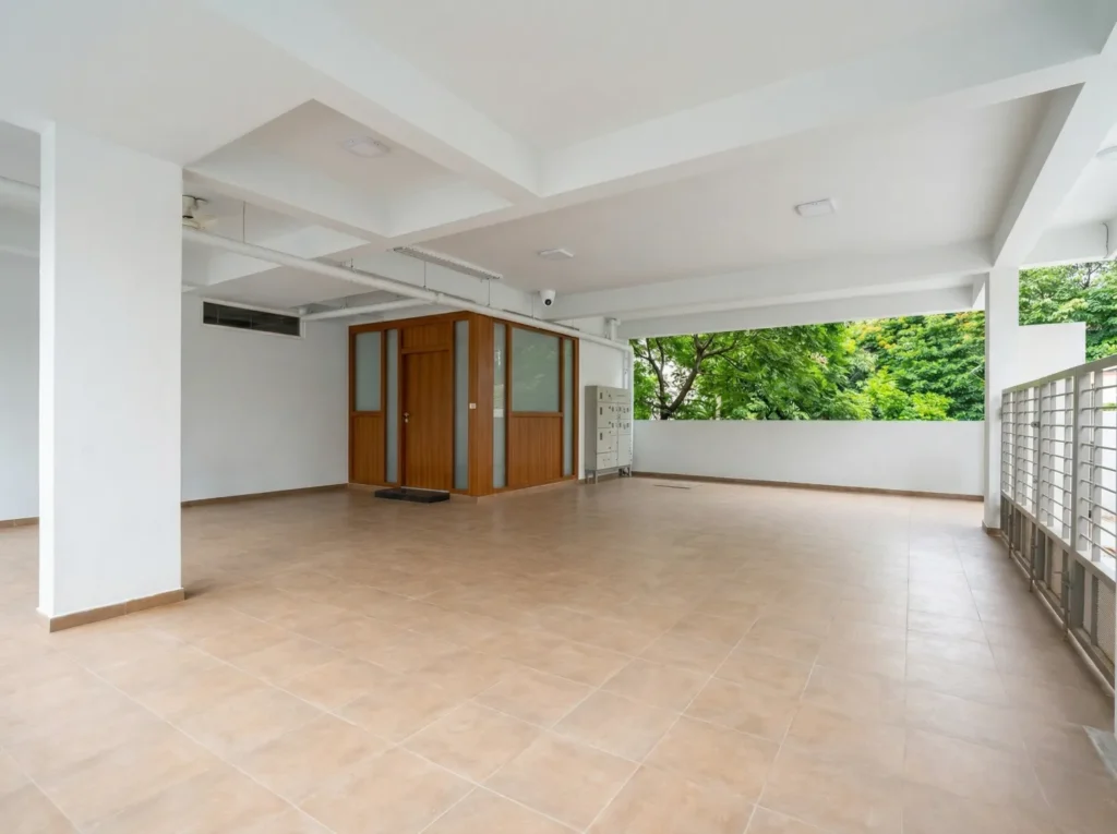 Spacious stilt floor car parking area with durable anti-skid floor tiles and professional structural pillar support.