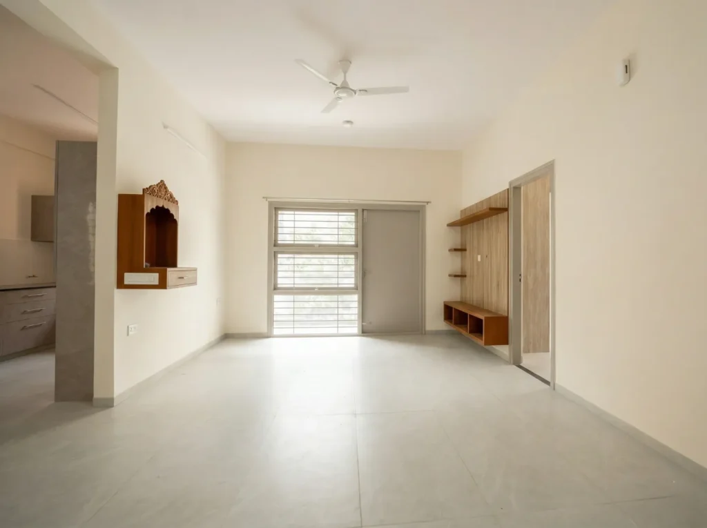 Minimalist living room interior featuring a wall-mounted wooden Pooja unit, TV console, and sleek vitrified tile flooring.