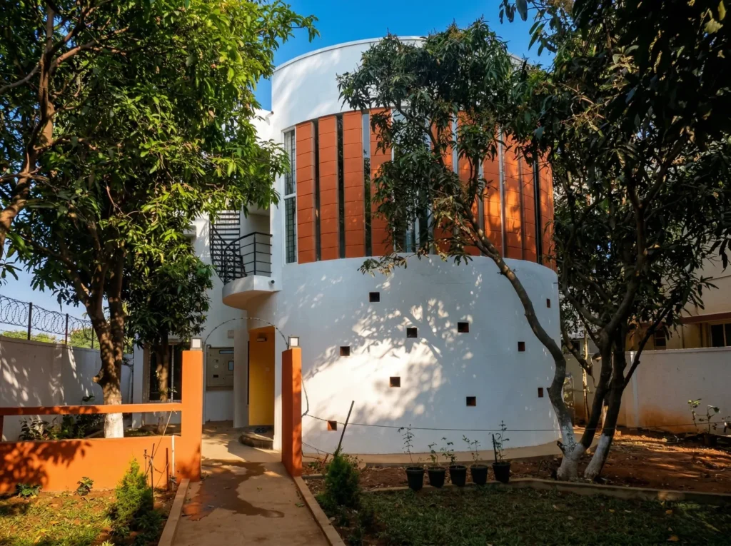 Modern eco-friendly home design with a curved exterior, sustainable terracotta cooling vents, and professional landscape integration.