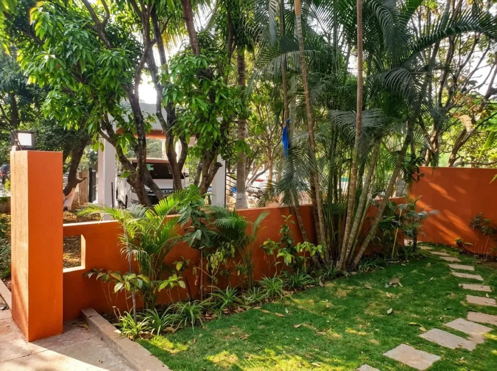 Luxury residential landscaping featuring a natural stone stepping path, manicured green lawn, and tropical palm trees.