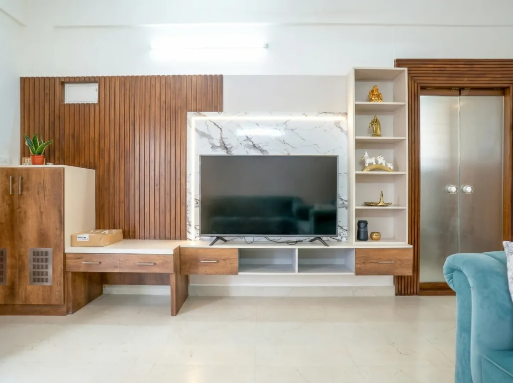 Custom TV unit with marble back panel and wooden louvers by an interior construction expert.