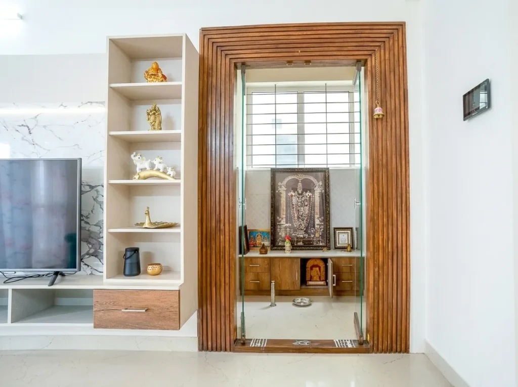 Traditional wooden puja room entrance with intricate carvings from a home construction project.