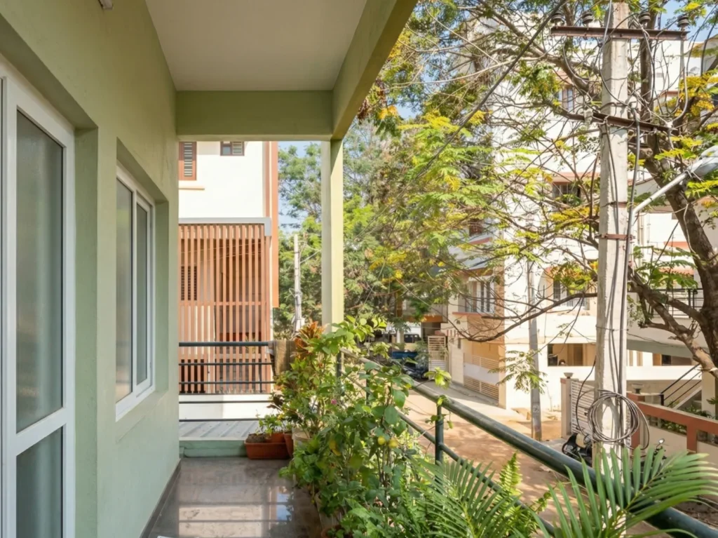 Modern balcony design with durable MS (Mild Steel) railings, granite flooring, and an integrated planter box for urban greenery.