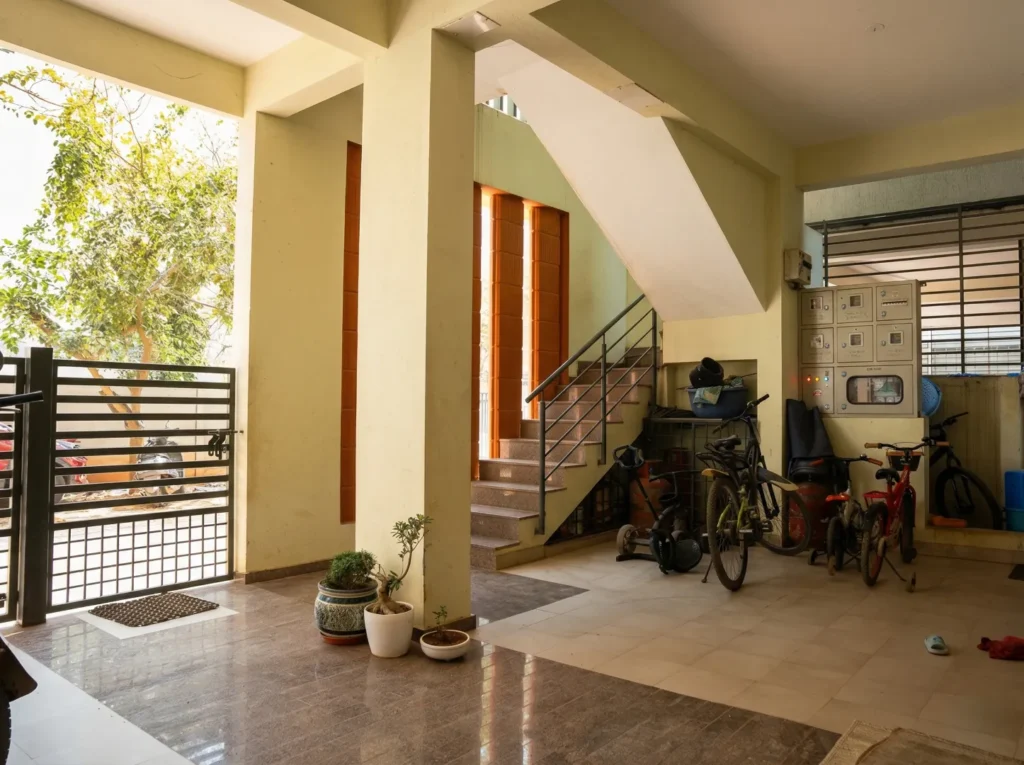 Professional turnkey construction of a stilt parking area featuring a custom MS sliding gate, granite stairs, and secure electrical panel housing.