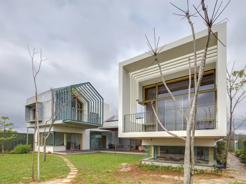 Modern home construction in Bangalore with layered facade, open balconies, and landscaped garden by High Tech Constructions