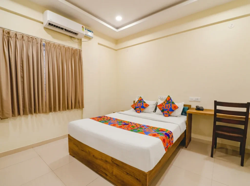 Minimalist bedroom interior with wooden furniture, part of a home construction in Bangalore project.