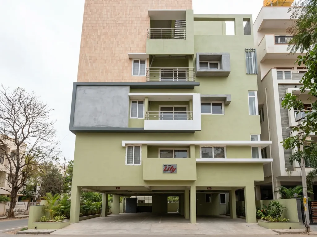 High Tech Lily multi-storey residential building with sage green facade, stone cladding tower, and stilt parking in Bangalore.