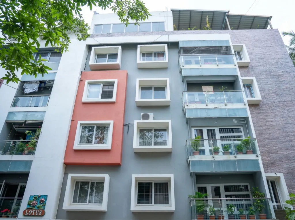 Multi-storey Lotus residential building exterior with grey and terracotta facade, glass balconies in Bangalore.