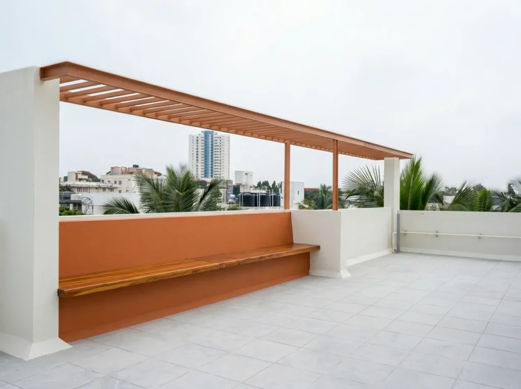 Rooftop terrace with timber pergola, built-in wooden bench, terracotta parapet wall, and Bangalore city views — residential construction.